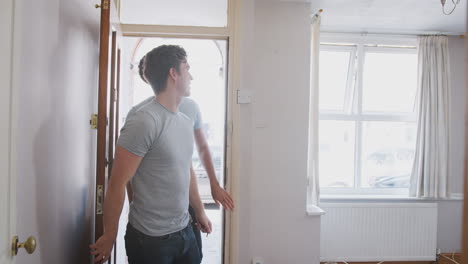 excited male couple opening front door of new home