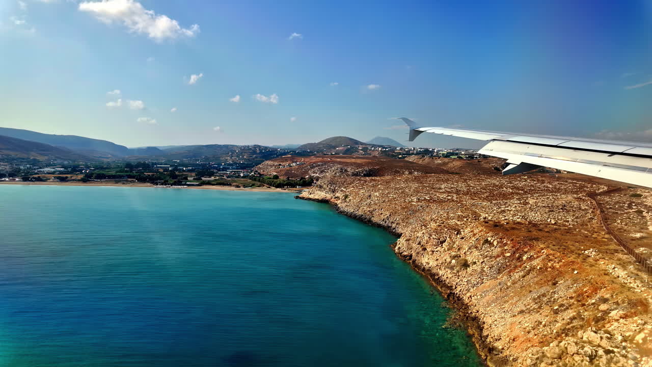 Landing with the plane on Crete, Greece, view out of the plane, flying over water, POV on sunny day, copy space