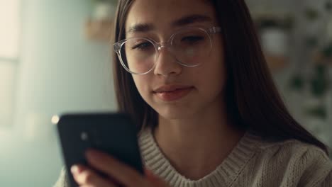 close up of caucasian teenage girl browsing phone in her bedroom