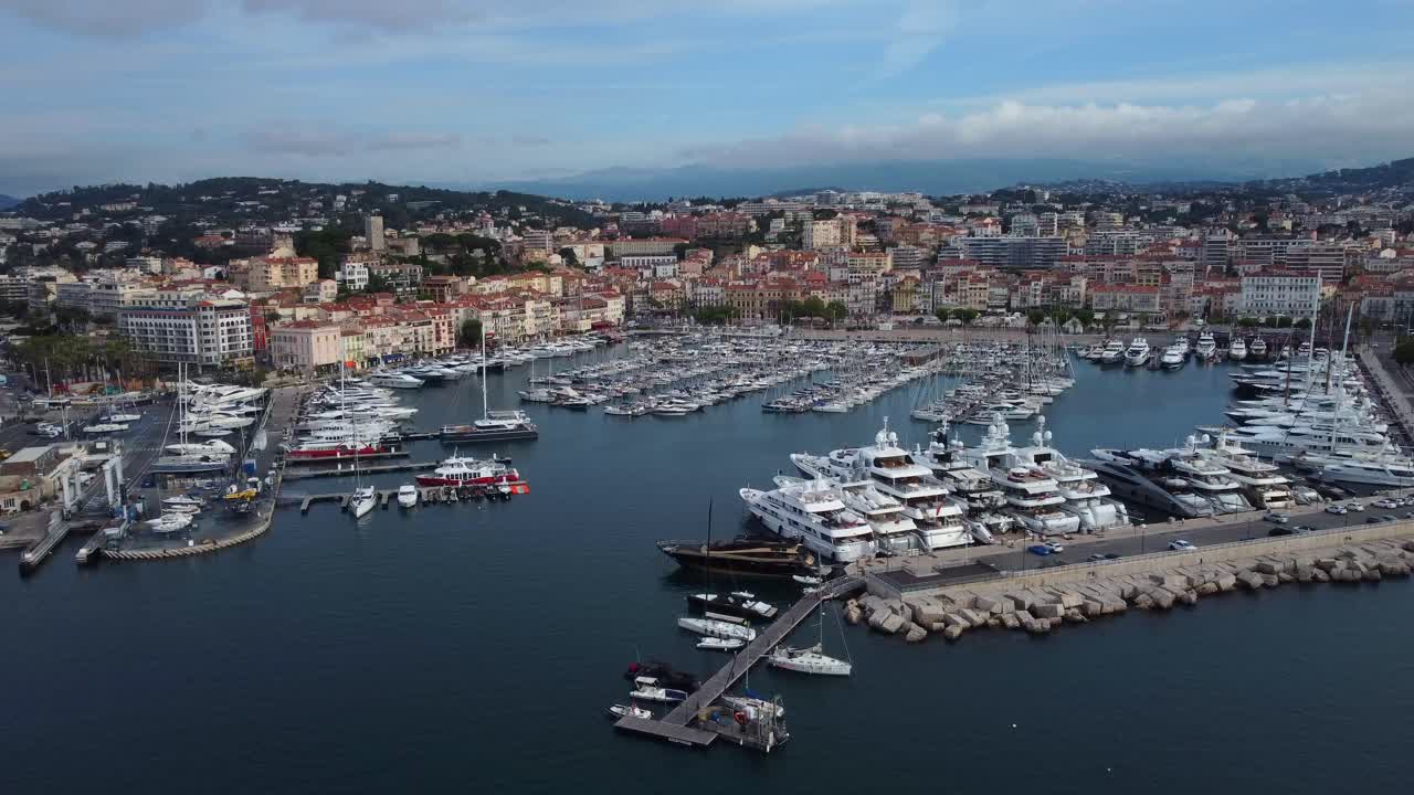 Lunga e lenta ripresa con drone che vola in avanti verso la città di Cannes in Francia.