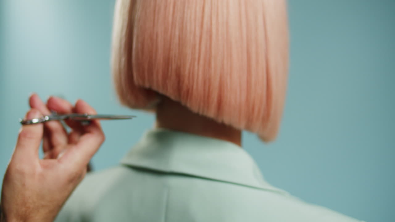 Hairdresser's hands making a trendy new hairstyle for a woman in a beauty salon