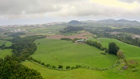 green countryside landscape in azores covered in mist clouds, aerial