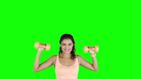 una joven bonita haciendo ejercicio con pesas.