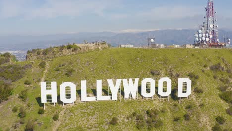 spectacular aerial of hollywood sign with snowy mountains in los angeles