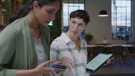 business women architects brainstorming working together using architecture plans female engineers working late collaborating sharing design ideas using tablet computer enjoying creative project