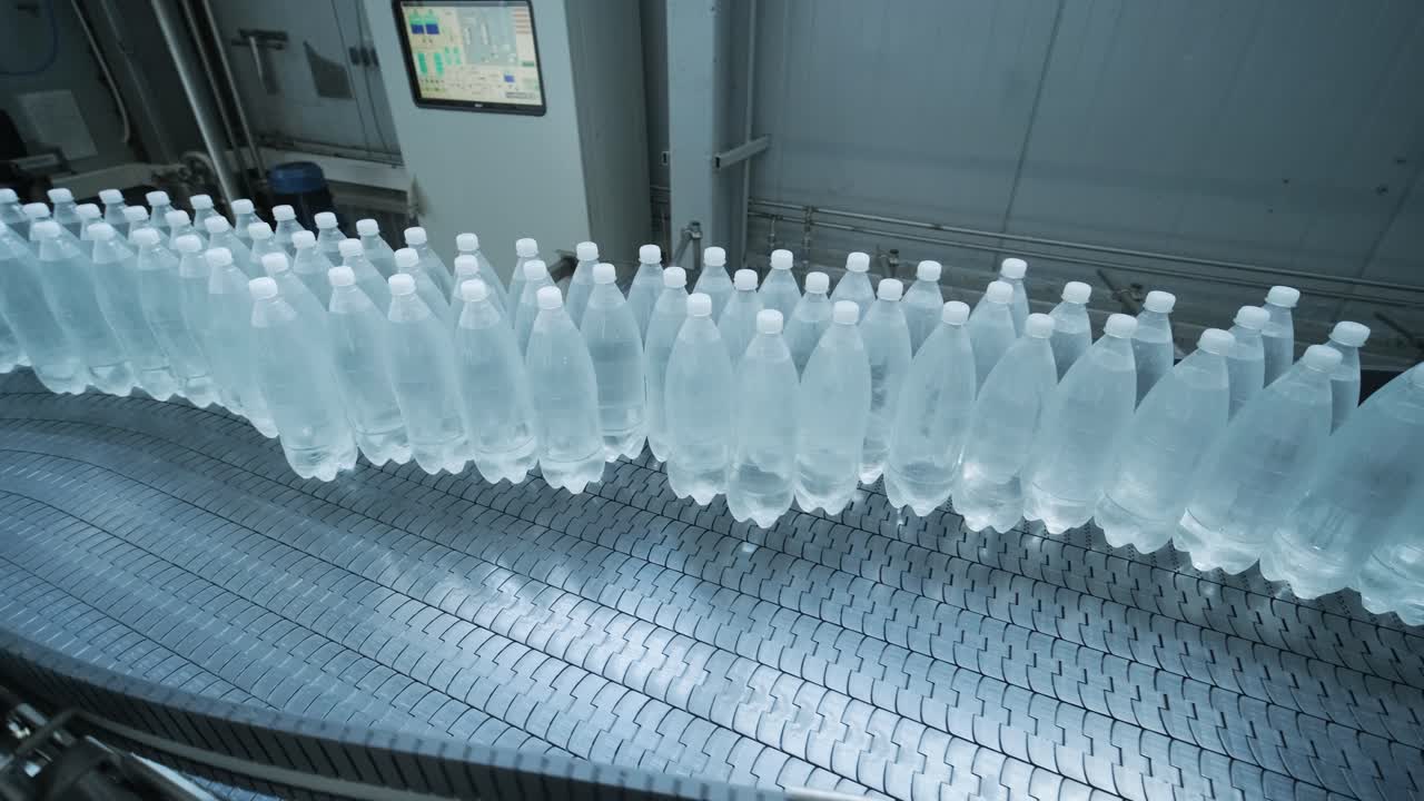 Conveyor belt with bottles of drinking water at a modern beverage plant