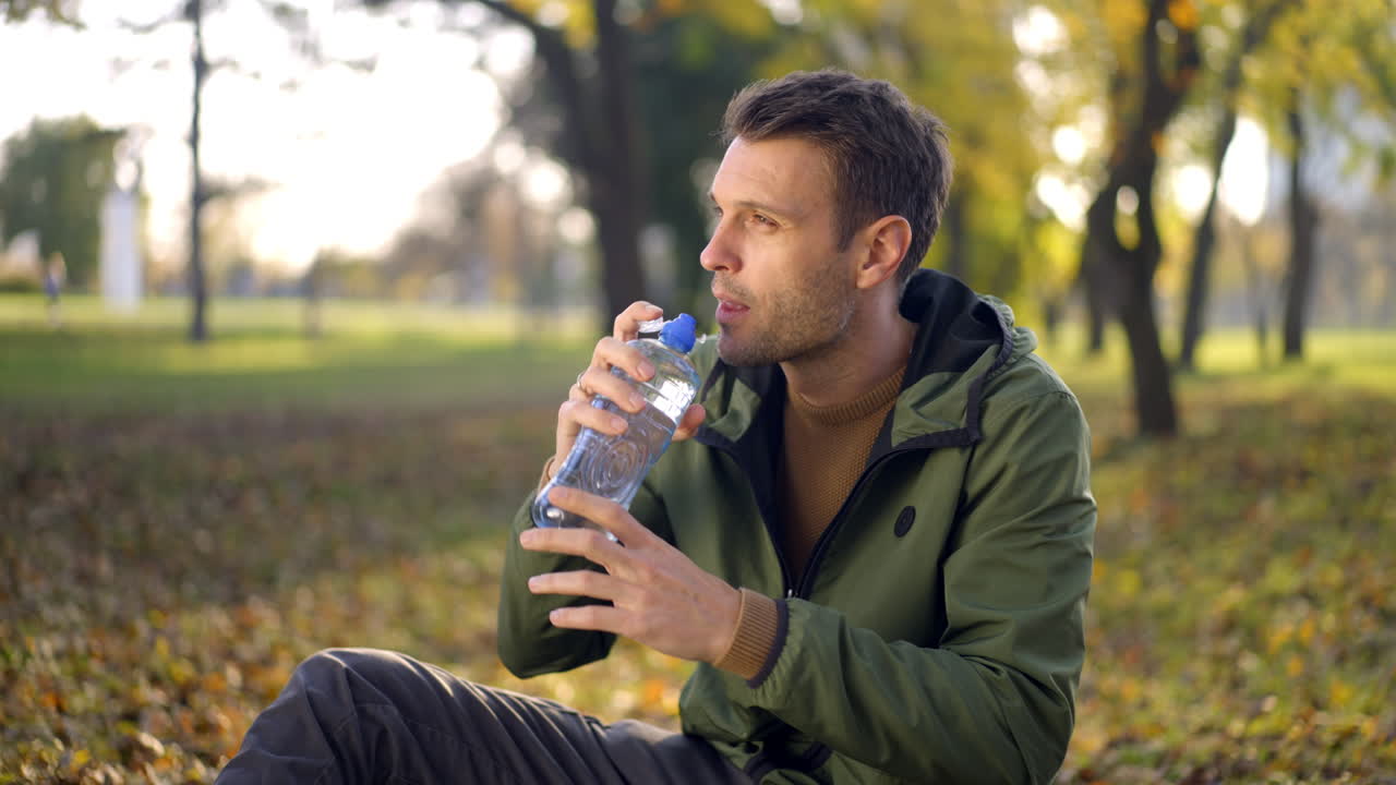 Man Drinking Water in the Park