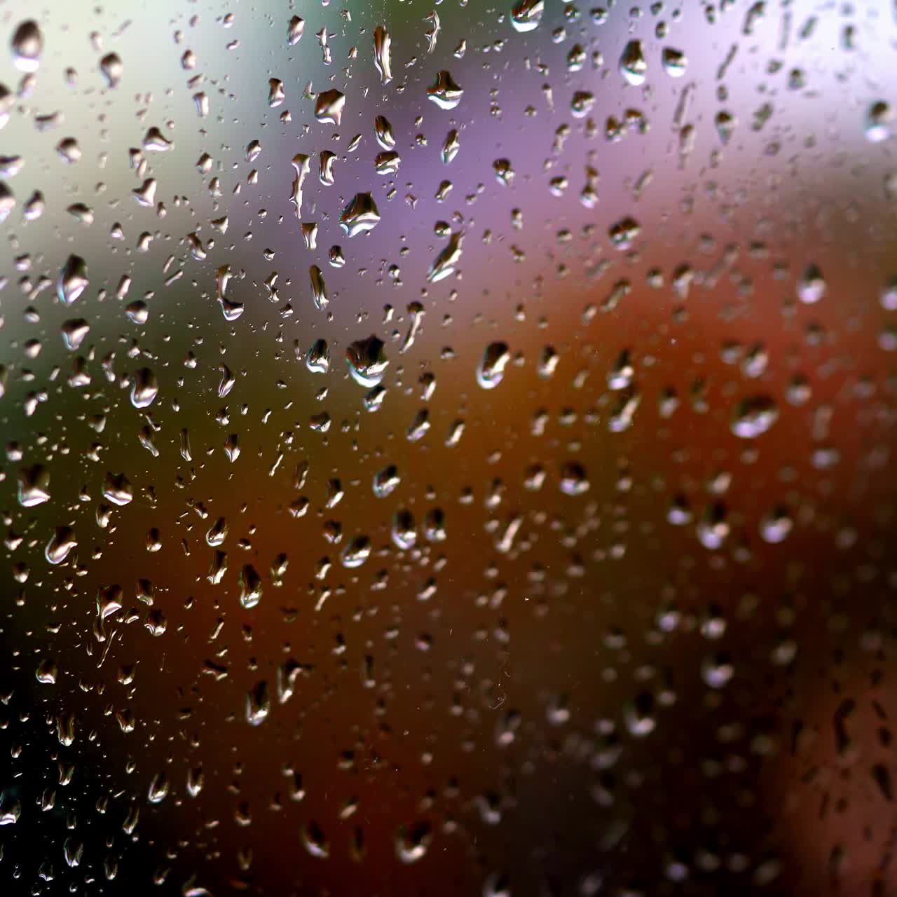 Water drops background. Rain drops on glass window in rainy season. Large raindrops strike on a window frame. Close-up.