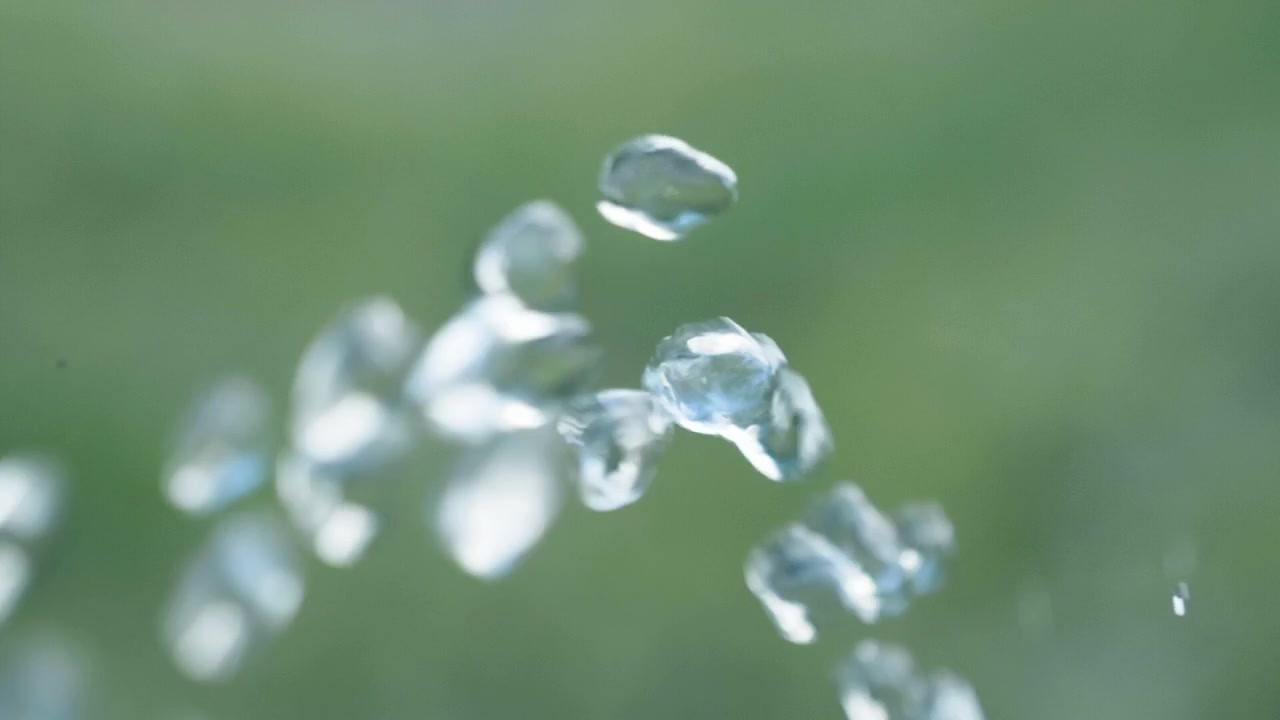 Pure water droplets passing camera in Slowmotion with green background - 180fp