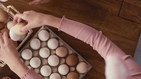 Top-view-of-child's-hands-arranging-easter-eggs-on-the-table.