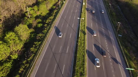 Aerial-flyover-busy-highway-with-cars-and-trucks-beside-green-rural-roadside-during-sunset-time---Buenos-Aires,Capital-of-Argentina