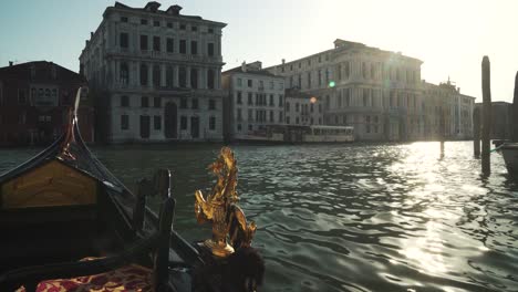 gondola sailing in venice on a sunny evening, canal with public transportation