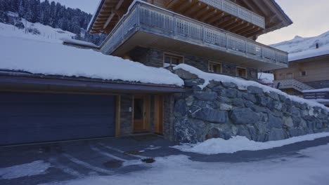 Tilt-down-of-beautiful-snow-covered-chalet-to-front-entrance