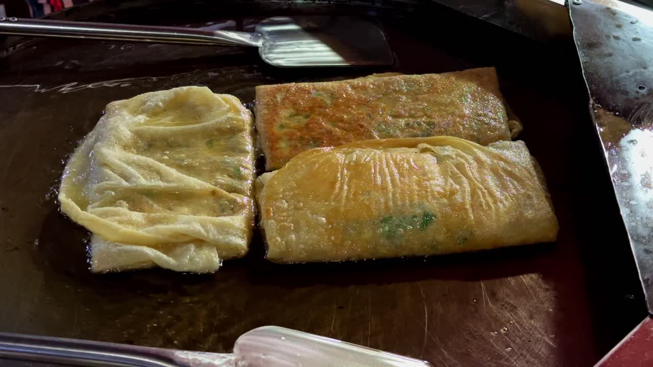 Murtabak being cooked on a griddle