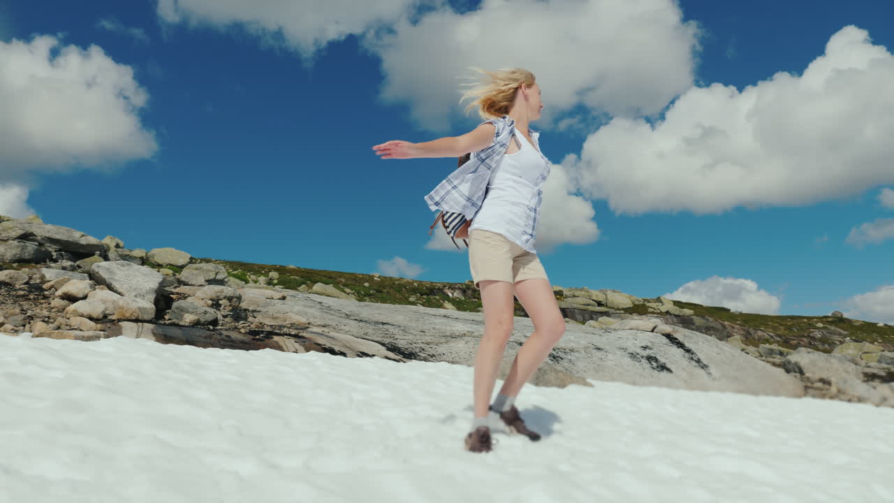 una mujer se regocija emocionalmente en la nieve en el verano del parque nacional haddarwid pero la nieve no se ha derretido