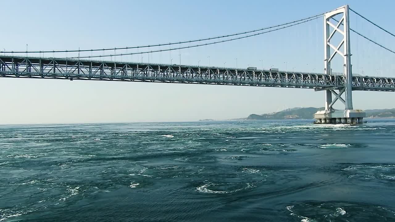 Water swirls emerge nsturally underneath the Akashi Kaikyo bridge