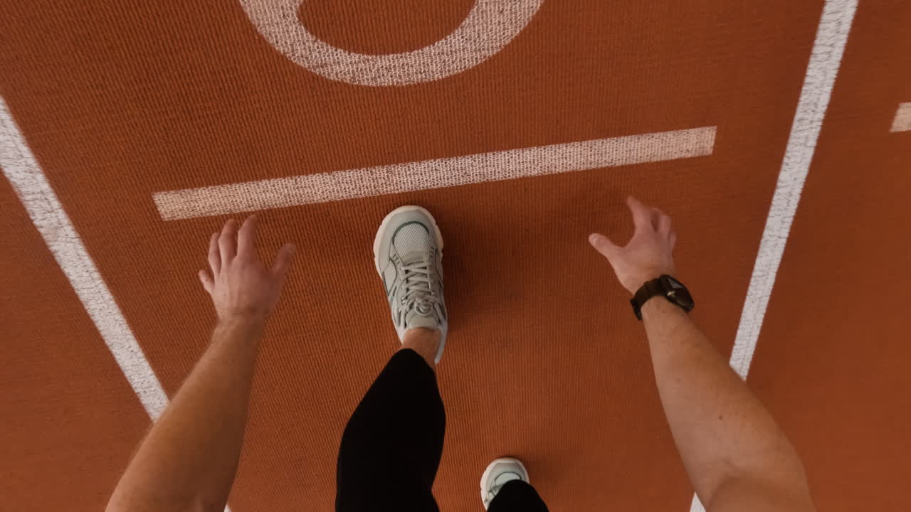 POV of an athlete at the starting line of a running track, ready to begin a race