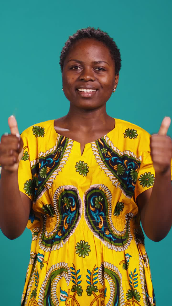 Donna africana felice che fa il pollice in su e celebra il successo