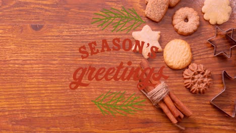 animation of christmas greetings text over christmas cookies and decorations