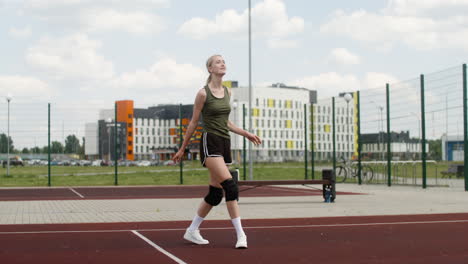 mujer rubia golpeando una pelota de voleibol