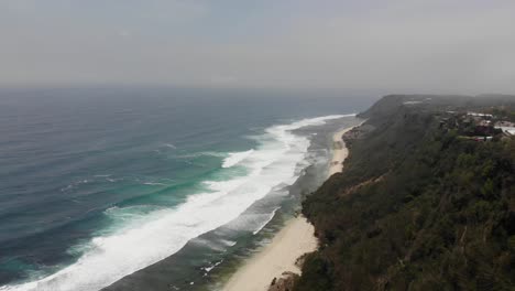 Aerial-View-of-Tropical-Uluwatu-Beach,-Bali,-Indonesia-Cliffs-and-Ocean-Shoreline,-Coastline