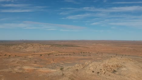 vast arid landscape with sparse vegetation and blue sky