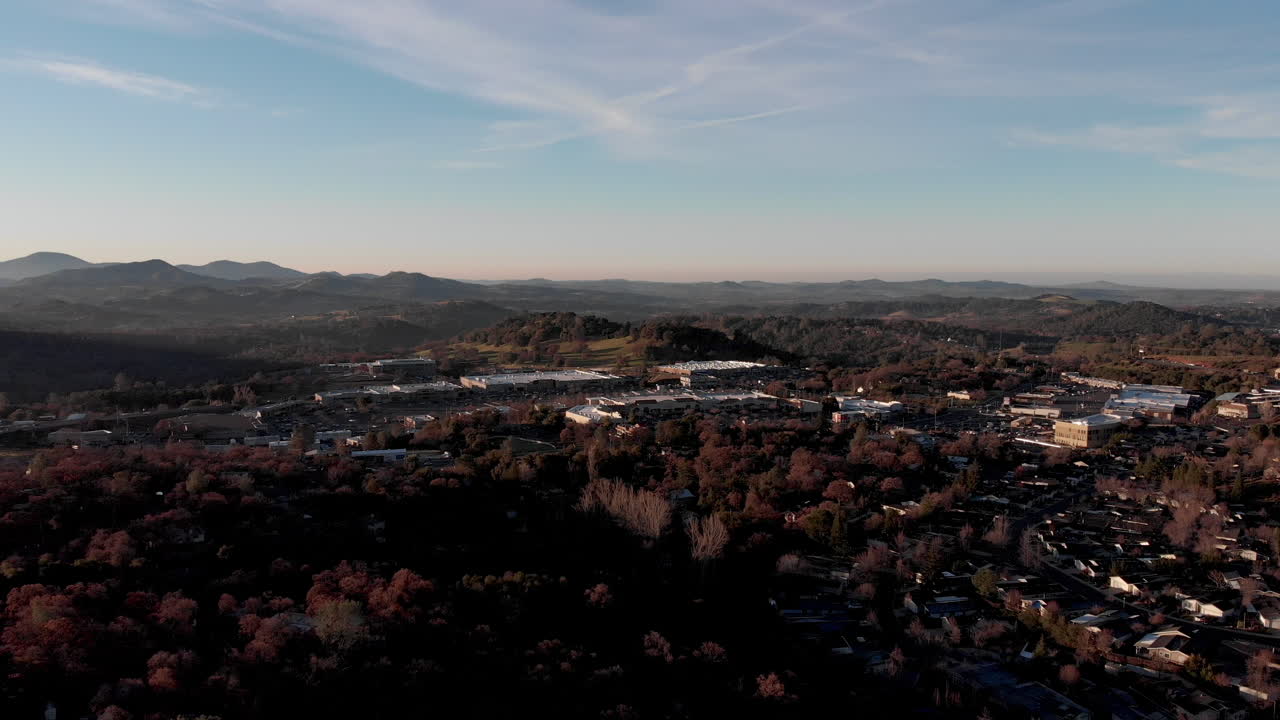 캘리포니아 반도의 산과 숲 근처의 파란 하늘에서 드론이 이륙하여 100 마일의 전망을 열고 있습니다.