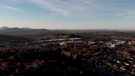 Un-Dron-Despega-En-Cielos-Azules-Cerca-De-Las-Montañas-Y-Bosques-De-La-Península-De-California-Abriendo-Una-Vista-De-100-Millas