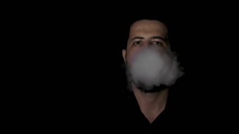 man smoking and blowing smoke in front of the camera