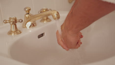 man washing his hands in sink