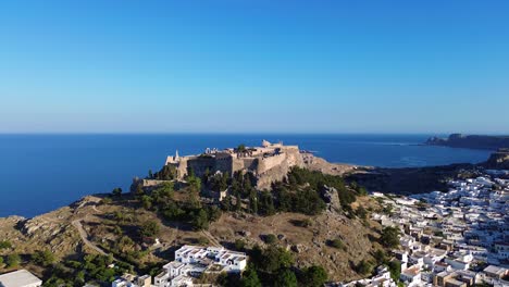 Akropolis-Von-Lindos-In-Rhodos,-Griechenland-Mit-Häusern-Und-Mittelmeer-Während-Des-Tages,-Gefilmt-Mit-Der-Drohne