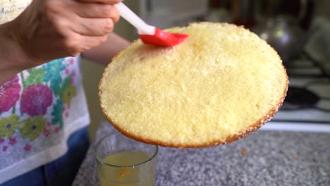 Moistening-Sponge-Cake-With-Peach-Syrup.-closeup