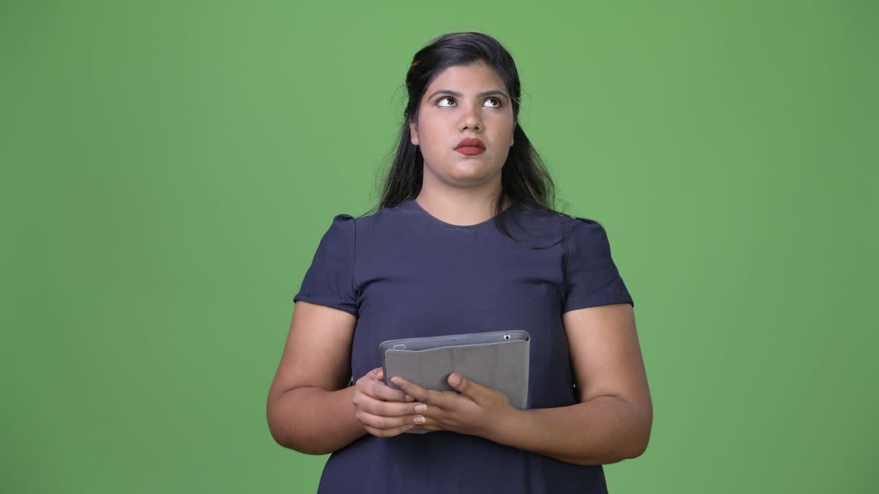 joven sobrepeso hermosa mujer de negocios india contra fondo verde