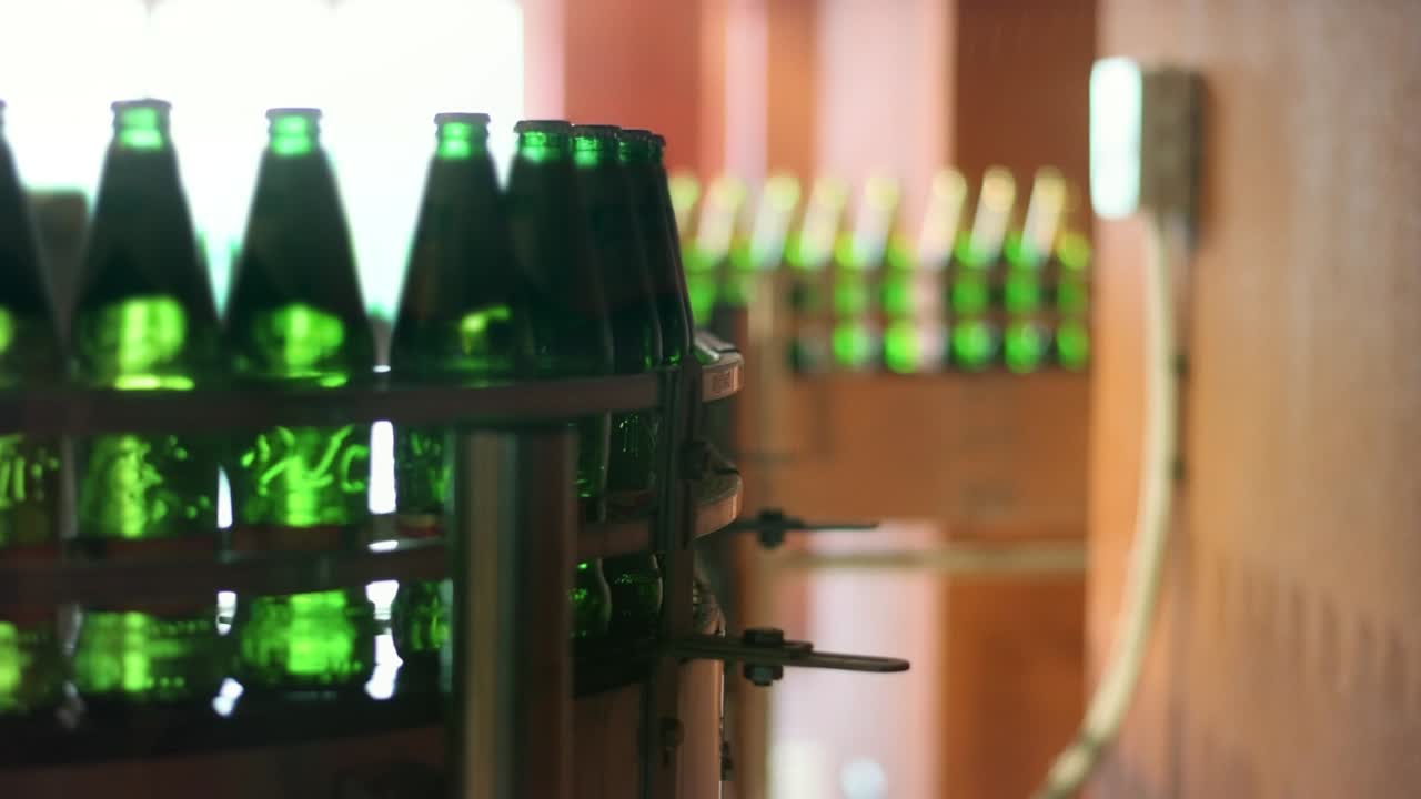 botellas de cerveza que se mueven en cinta transportadora en la fábrica. línea de fabricación automatizada