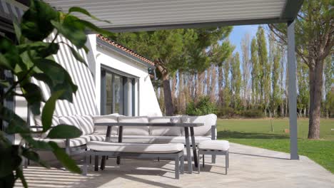 slow establishing shot of comfortable patio furniture under a sunshade