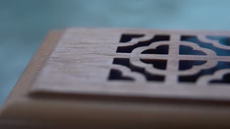 A-close-up-macro-shot-of-smoking-incense-in-a-wooden-box,-spiritual-ritual-meditation,-scented-therapy-fragrance,-relaxing-aromatic-white-smoke,-cinematic-4K-video-pan-right