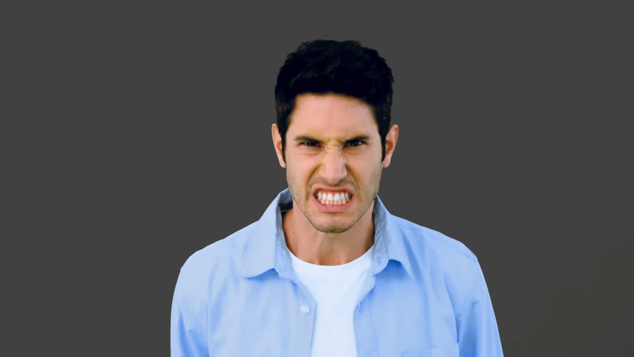 Man growling at camera angrily on grey background