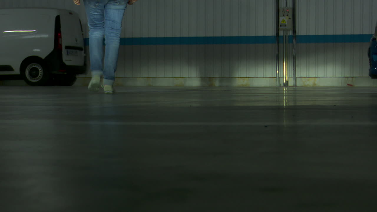 Person Walking in a Parking Garage at Night