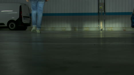 person walking in a parking garage at night