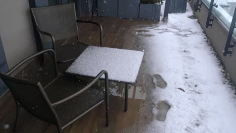snowy balcony patio with outdoor furniture