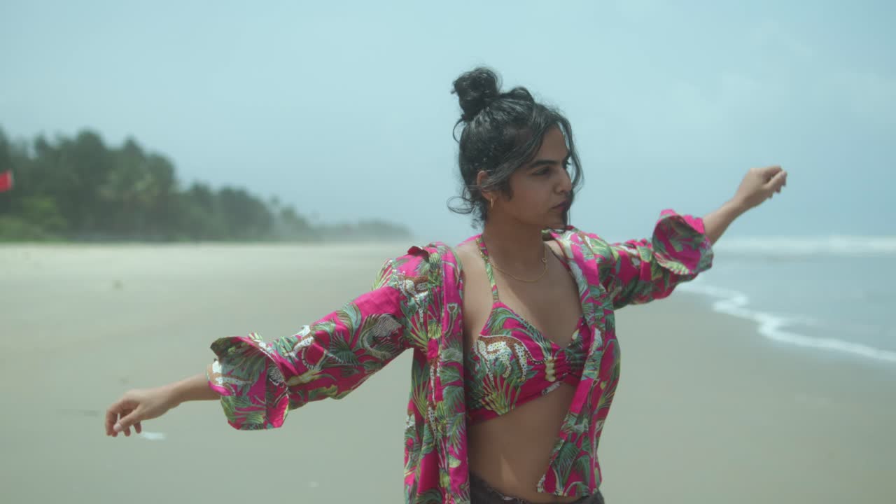 Joyful woman dancing on a sunny, sandy beach with a carefree spirit