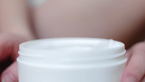 female hand applying moisturizing cream. close up shot