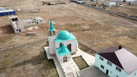 aerial: small mosque is shining in sunrise.