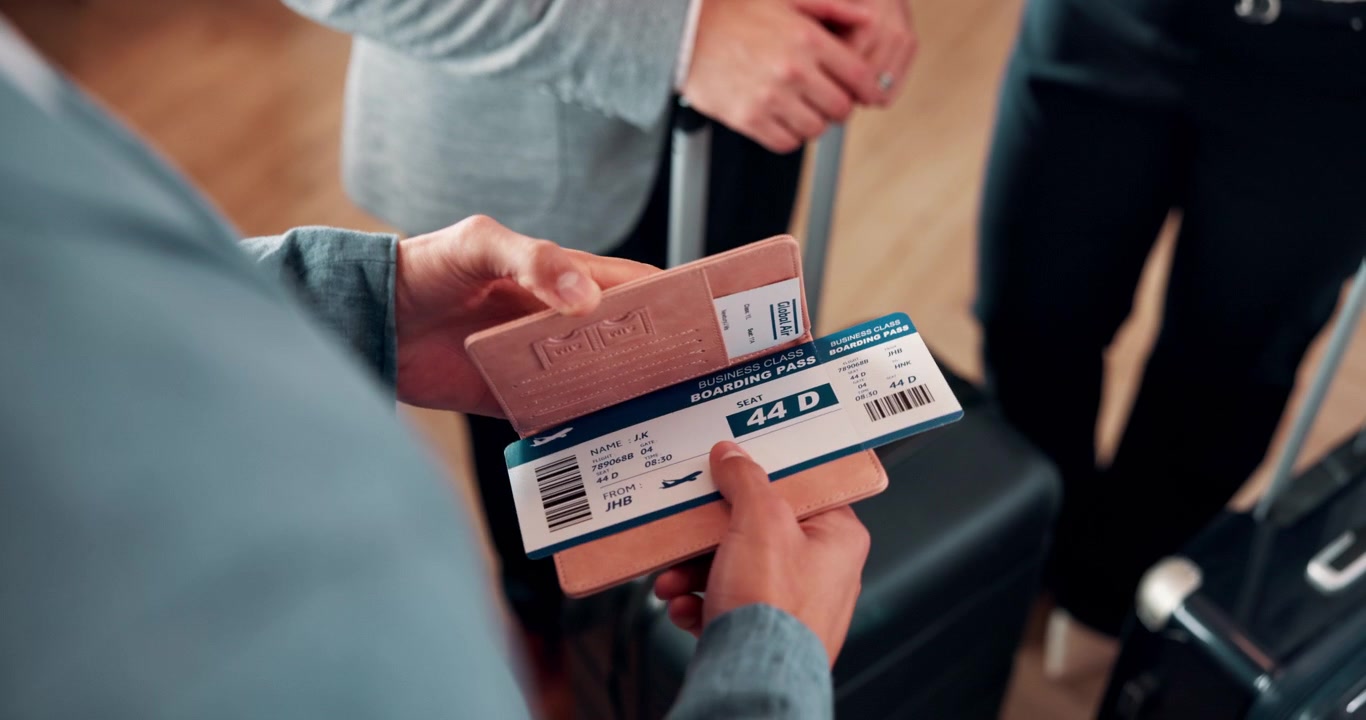 Person Holding Passport and Boarding Pass at Airport