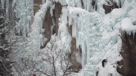 ice climber on frozen waterfall in ouray ice park, colorado usa slow motion wide view