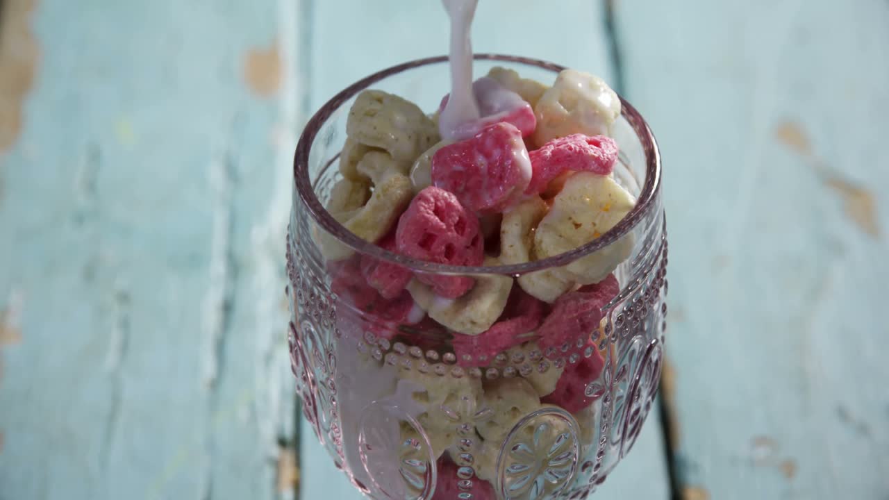 우유는  ⁇ 집 시리얼 4k의 유리잔에 부어지고 있습니다.