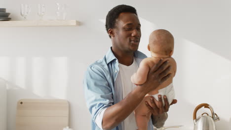 african american father bonding with baby at home