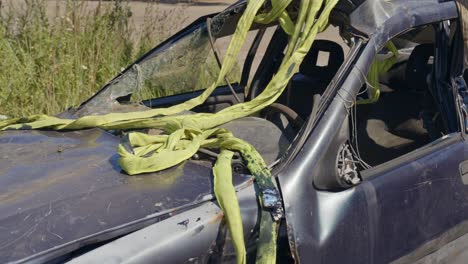 preparándose para tirar de un automóvil destruido en un accidente de una zanja con una correa industrial