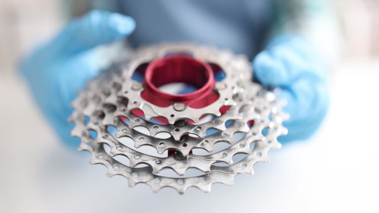 ingeniero sosteniendo la rueda de la bicicleta y comprobando la velocidad de transmisión de cerca