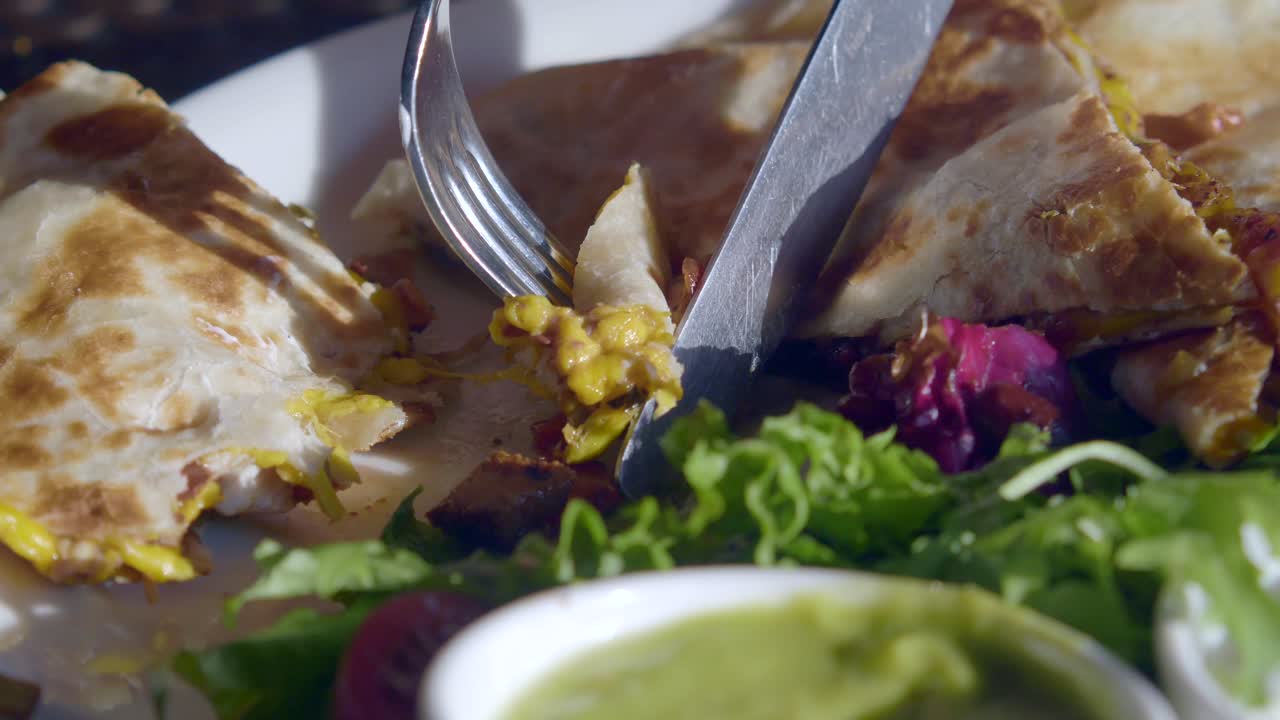 Quesadilla being cut on a plate